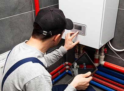 Technician Adjusting Controls on a Water Heater System